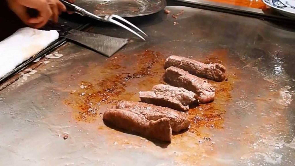 Chef preparing Kobe Beef and sides at Steak Land in Kobe, Japan