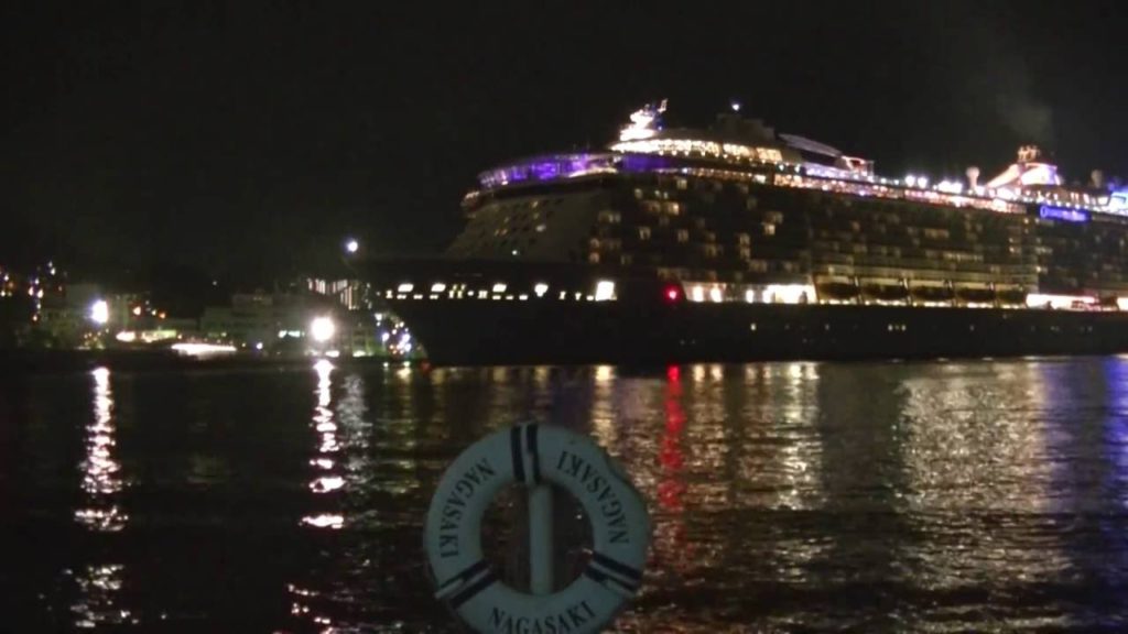 Time-lapse36 Ovation of the Seas departs from night Nagasaki Port while big turning.