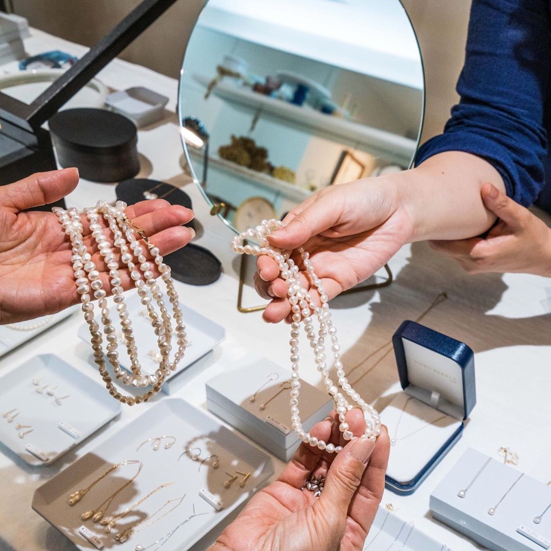 A clerk at Jinbo Pearls in Otsu shows a customer jewelry made from Lake Biwa pearls. | PHILIPPE VOISIN
