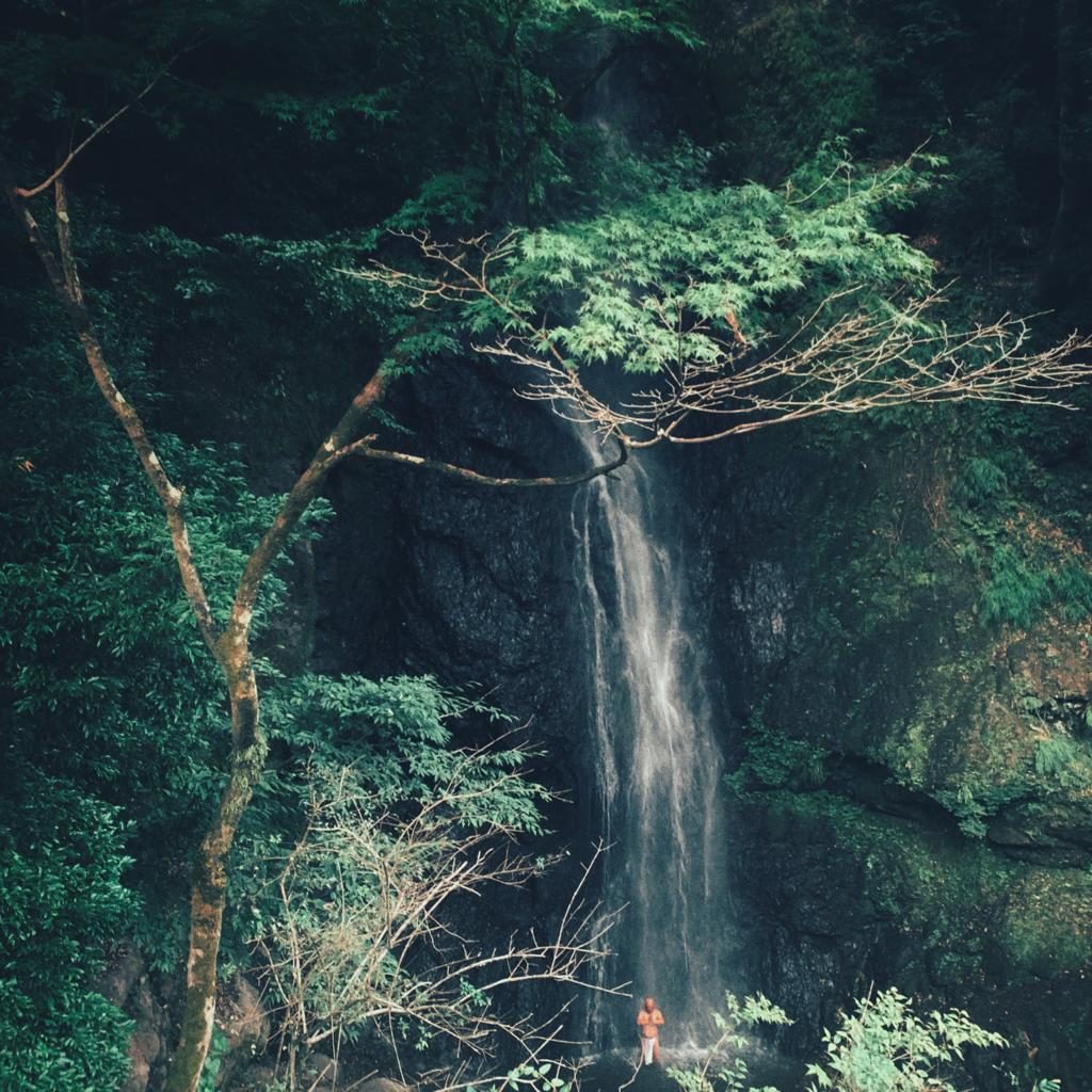 Buddhist meditating under waterfall.