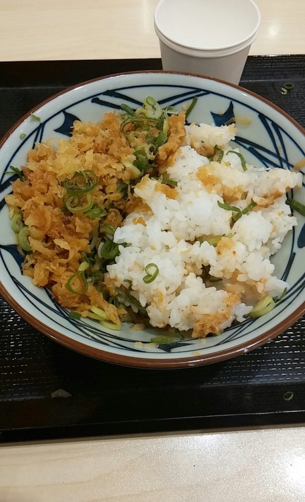 This is free "Marugame Don", popular among Japanese bad boys: First, borrow an bowl with soup left from the return counter and put rice ball brought from home in it. Sprinkle sesame paste, spring onion, tenkasu. (They are free) Second, Voila! finally you have made delicious "Marugame Don" for free!