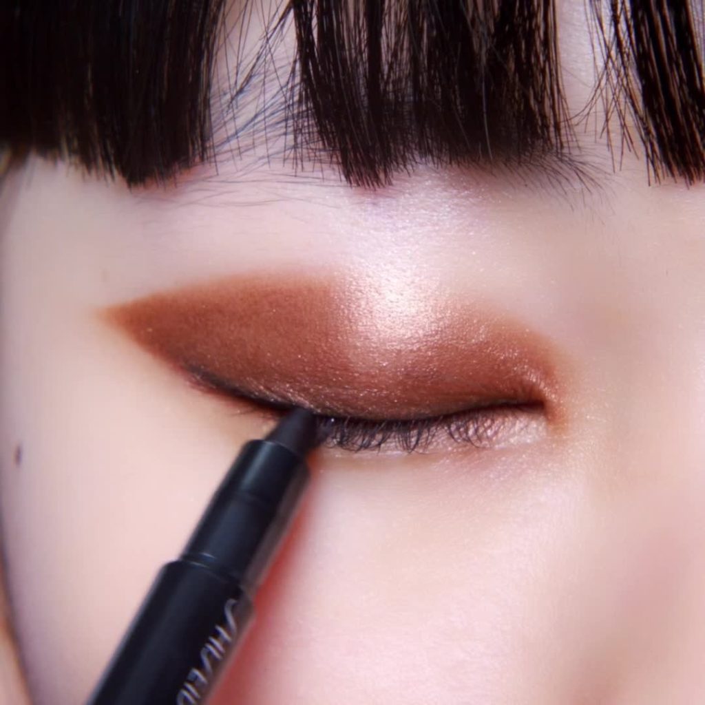 Wing it with Kajal InkArtist in Meiji Bronze for the holidays. Dramatically defi...