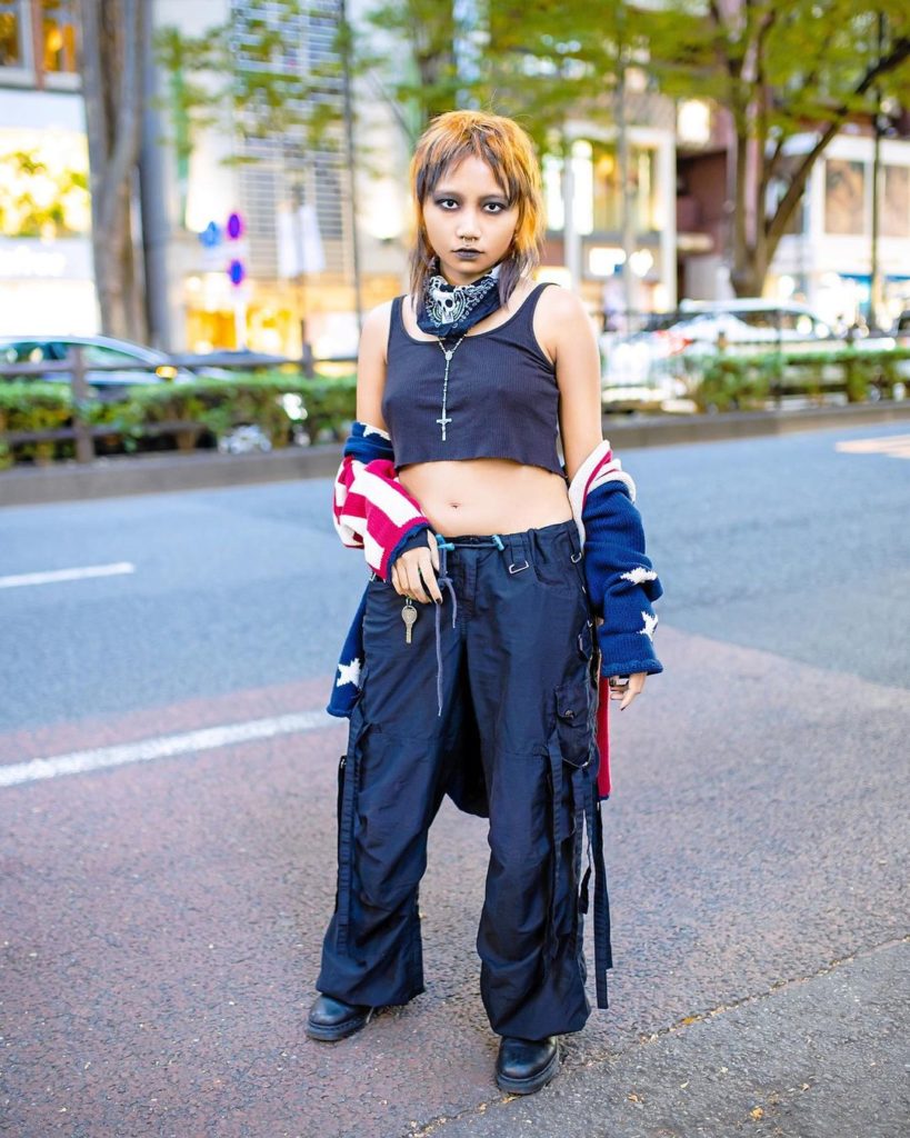 Diva (@sexrifice) on the street in Harajuku wearing a knit flag sweater over a c...