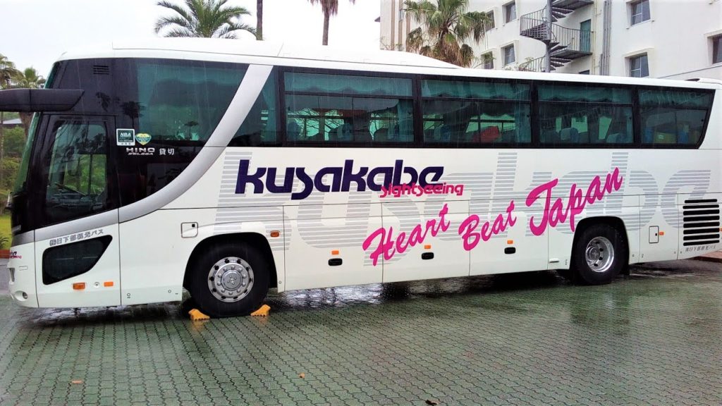 オリンピック聖火を支える観光バスとトラックコンボイ車列指宿を走る A convoy corps of sightseeing buses and trucks supporting the Olymp