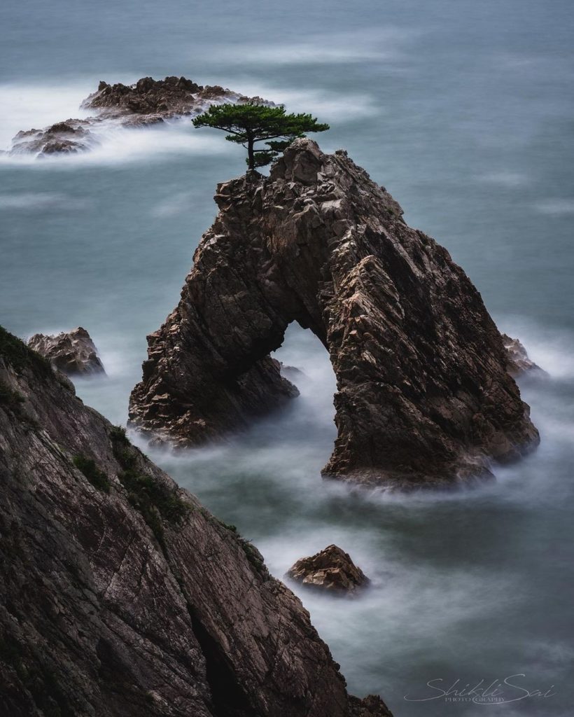 Is this a mountain above the clouds, or rock appearing out of water? 
This grani...