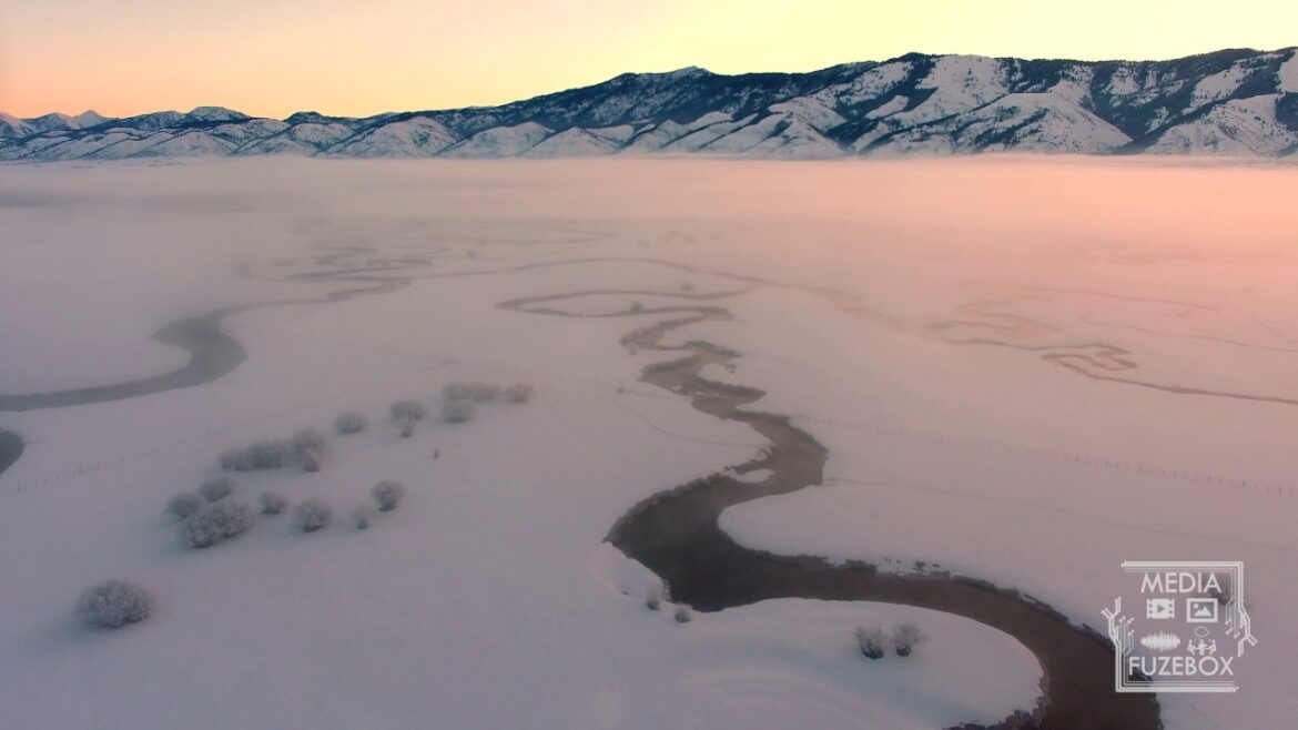 Aerial view of winding river during sunrise in winter