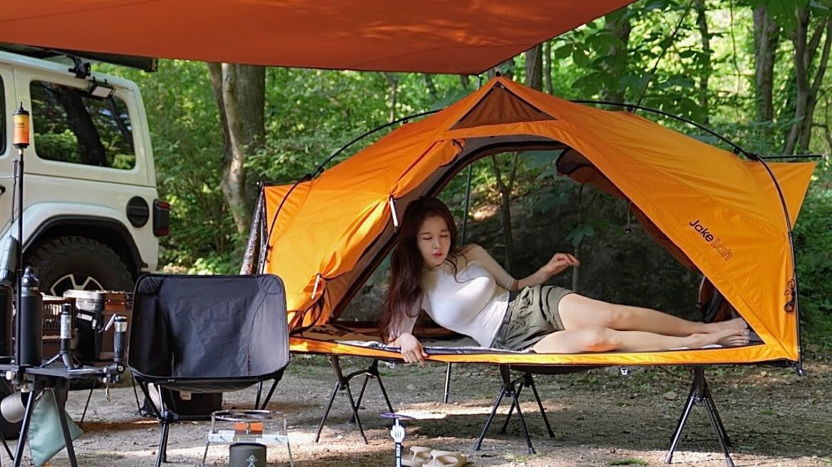 Wet girl in a valley camping alone in the wild mountains