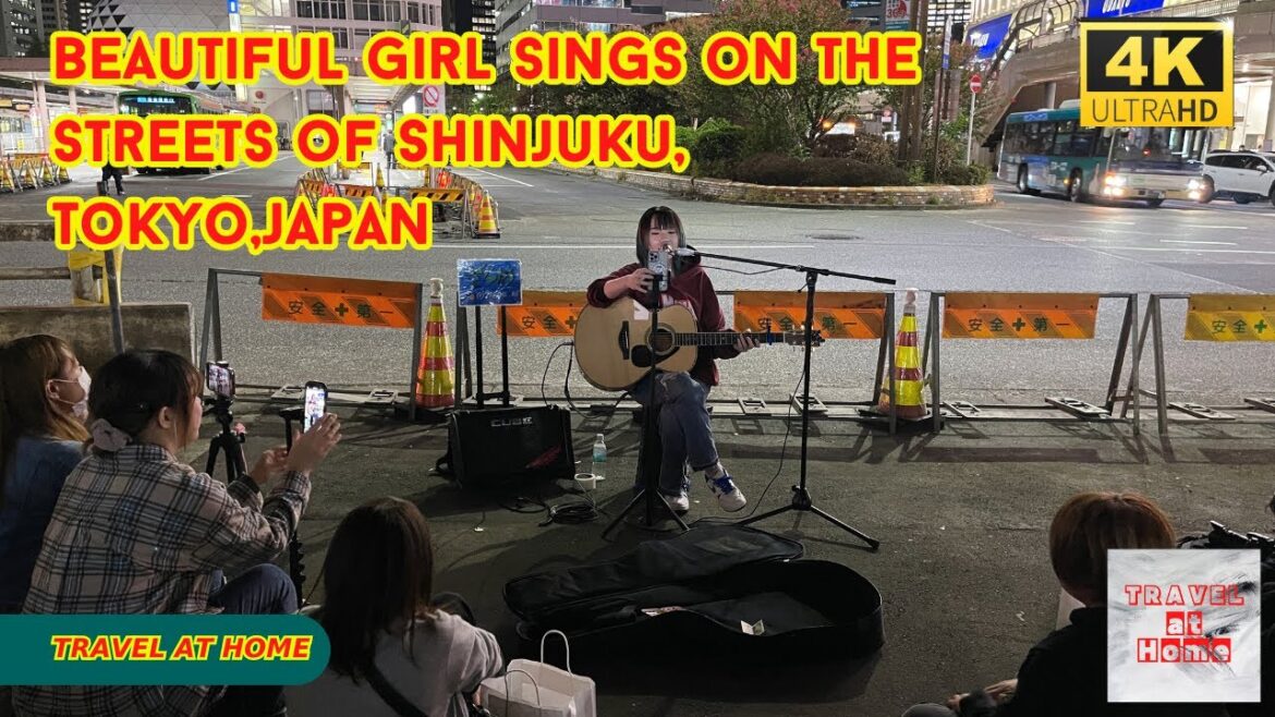 Beautiful girl sings on the streets of Shinjuku, Tokyo, fans sit on the floor and listen to the song Beautiful girl sings on the streets of Shinjuku, Tokyo, fans sit on the floor and listen to the song