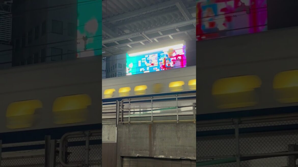 Shinkansen passing an advertisement at Shimbashi Station