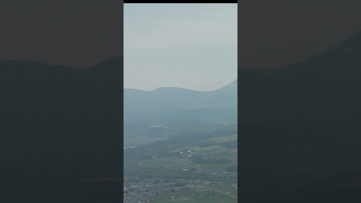 夏の北海道 十勝岳連峰まで見渡せる旭川空港着陸前のAIRDO-B767機内窓からの景色