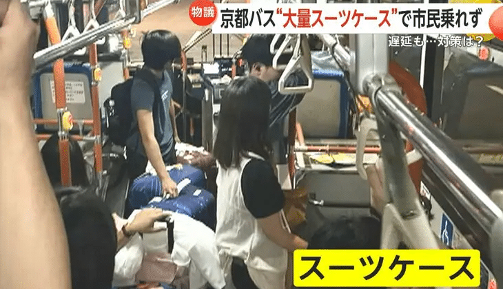 Tourists in Kyoto with their suitcases cramming a bus aisle