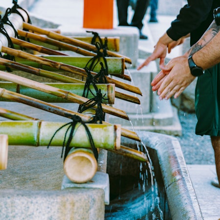 A man washes his hands at a public basin