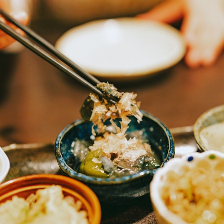 Rice and seaweed is pulled from a dinner bowl with chopsticks
