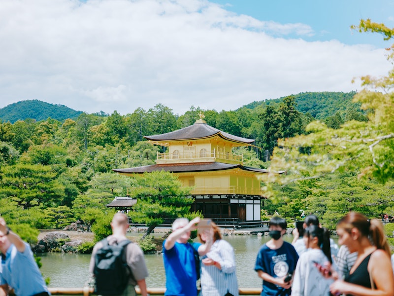 Tourists gather in front of a Zen temple on a sunny day