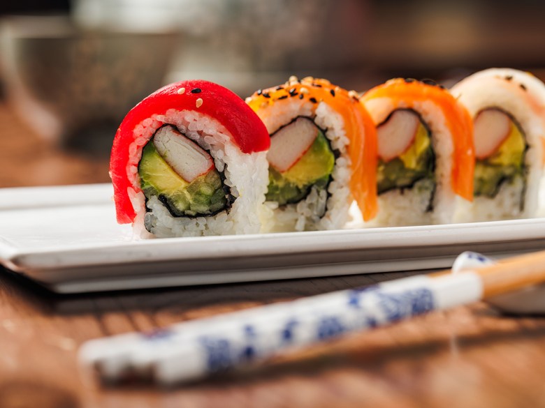 A sushi roll on a plate.