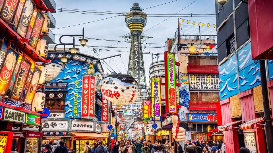 a busy street with a sign that says ' tokyo ' on it