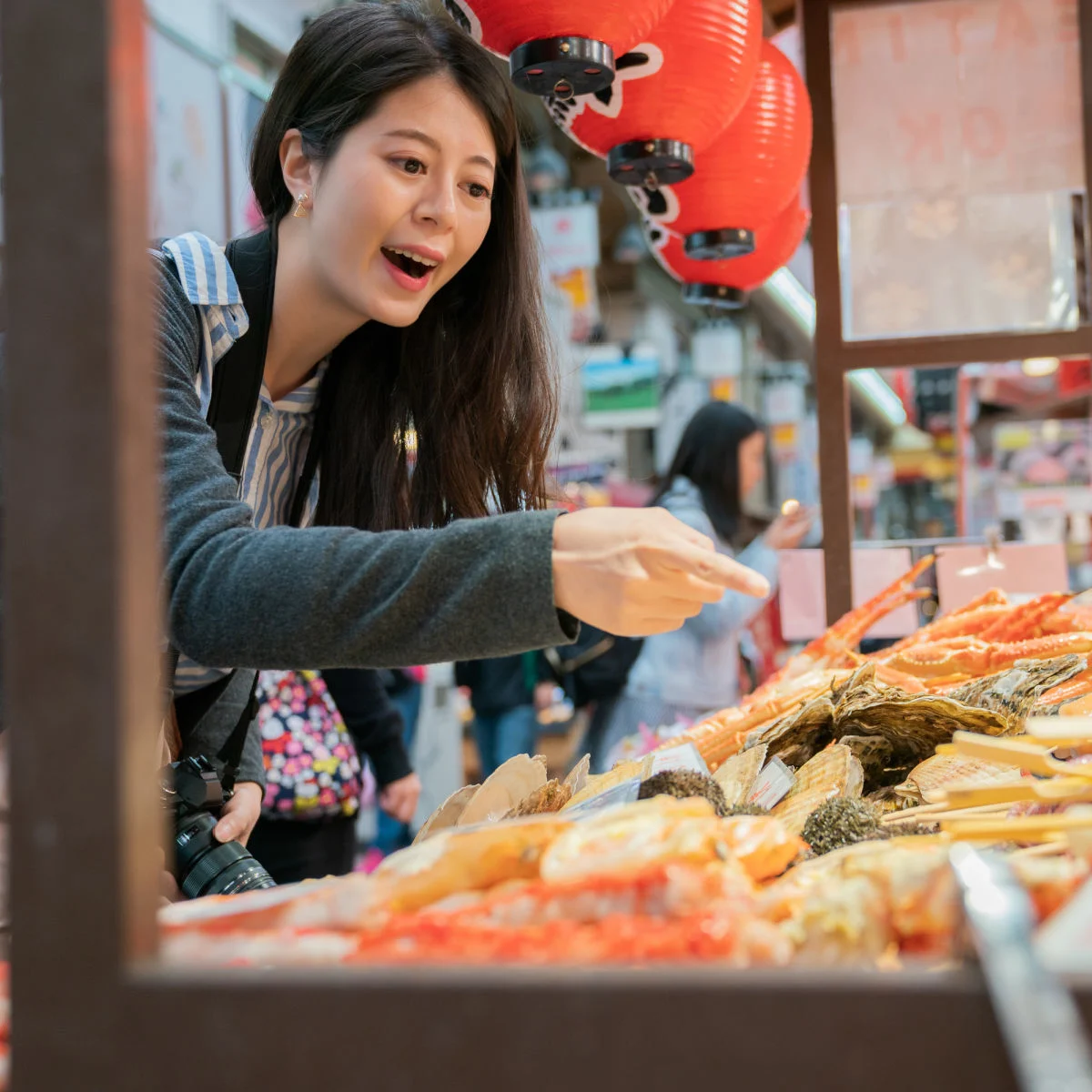 Woman ordering street food in Osaka, Japan
