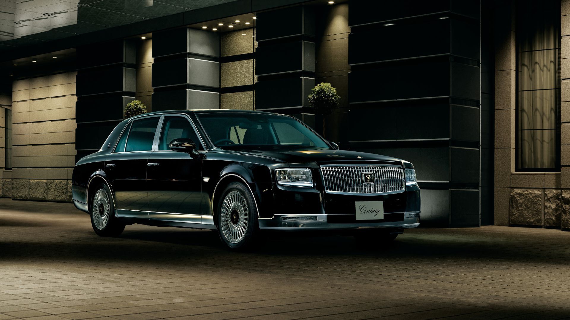 Front 3/4 view of a black 2018 Toyota Century parked outside of a building.