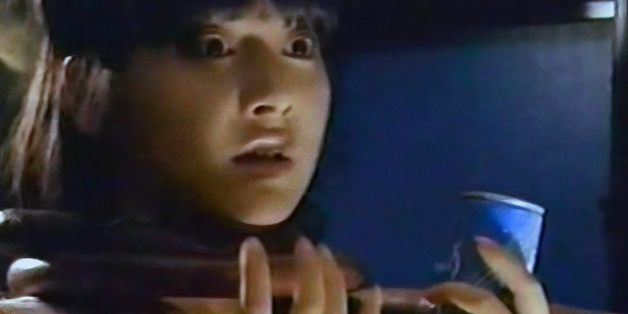 A woman looks ahead with a panicked look on her face. 