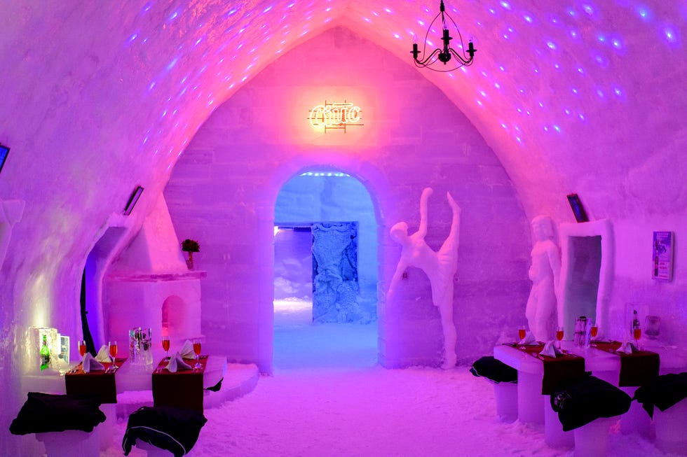 a room with a stage and a group of people in white clothing
