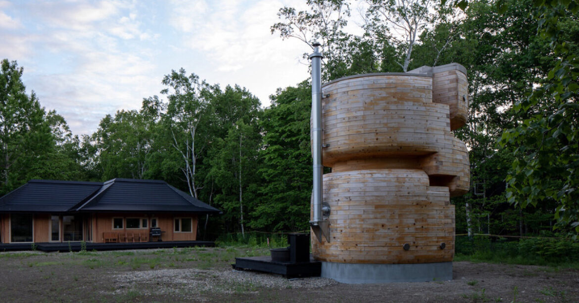 VUILD stacks curving prefabricated wood blocks to shape tower sauna in hokkaido