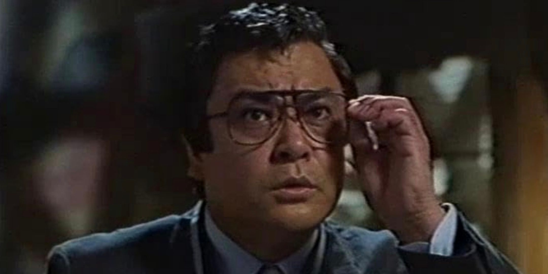  Shingo Yamashiro holds his glasses up to his face. 