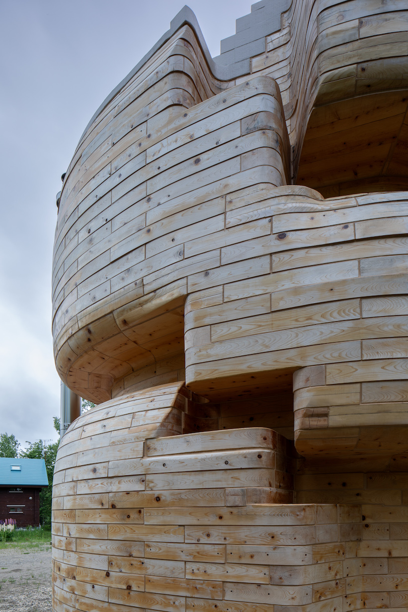 VUILD stacks curving prefabricated wood blocks to shape tower sauna in hokkaido