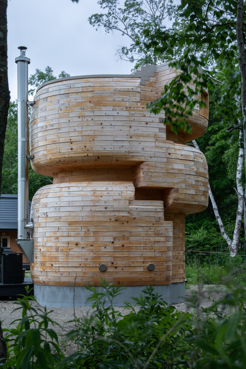 VUILD stacks curving prefabricated wood blocks to shape tower sauna in hokkaido