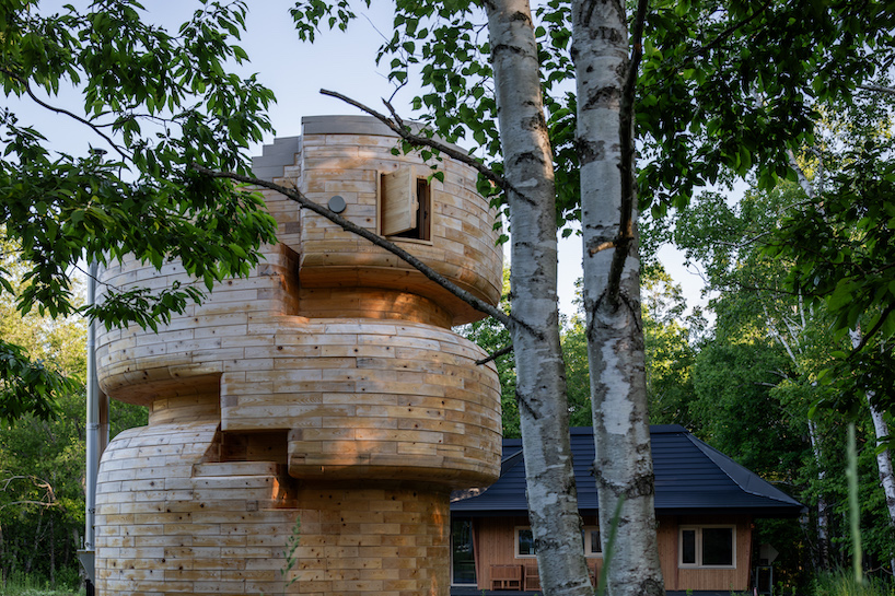 VUILD stacks curving prefabricated wood blocks to shape tower sauna in hokkaido