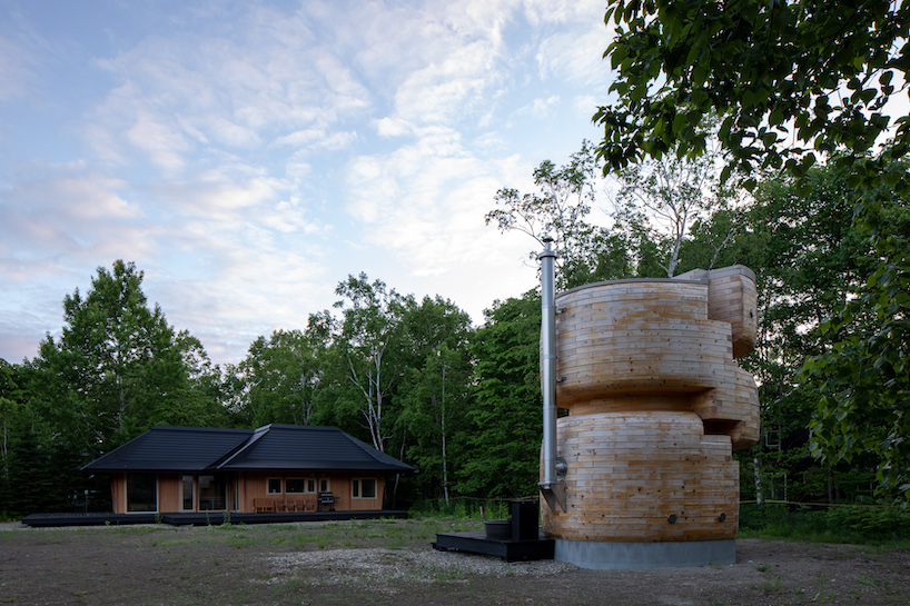 VUILD stacks curving prefabricated wood blocks to shape tower sauna in hokkaido