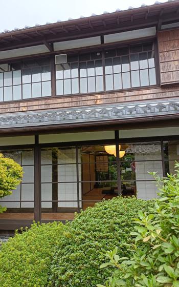 A traditional Japanese two-storied house with a garden.
