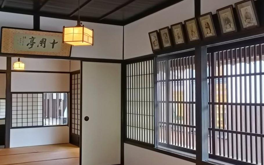 inside the building. tatai mats and some framed pictures can be seen.