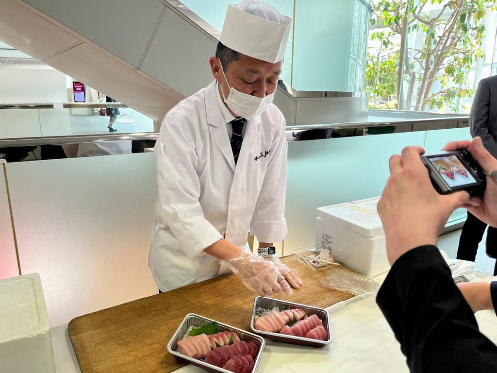 A sushi chef shows how different fatty and lean tuna look and serves both at a Fujitsu facility in Kawasaki, outside Tokyo. Photo: AP