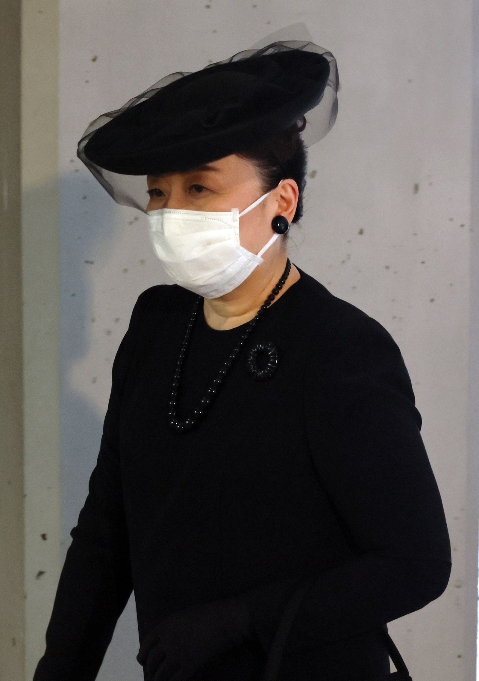 Image may contain Adult Person Accessories Jewelry Necklace Clothing Hat Earbuds and Electronics