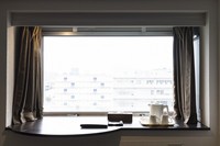 The bay window of a 10th-floor guest room is seen from the inside at the 