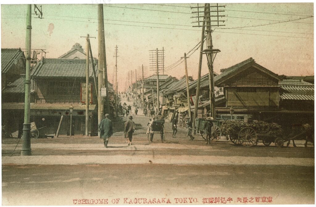 An old wooden Japanese townscape with houses with tiled roofs and ordered utility poles and power lines lining the street.