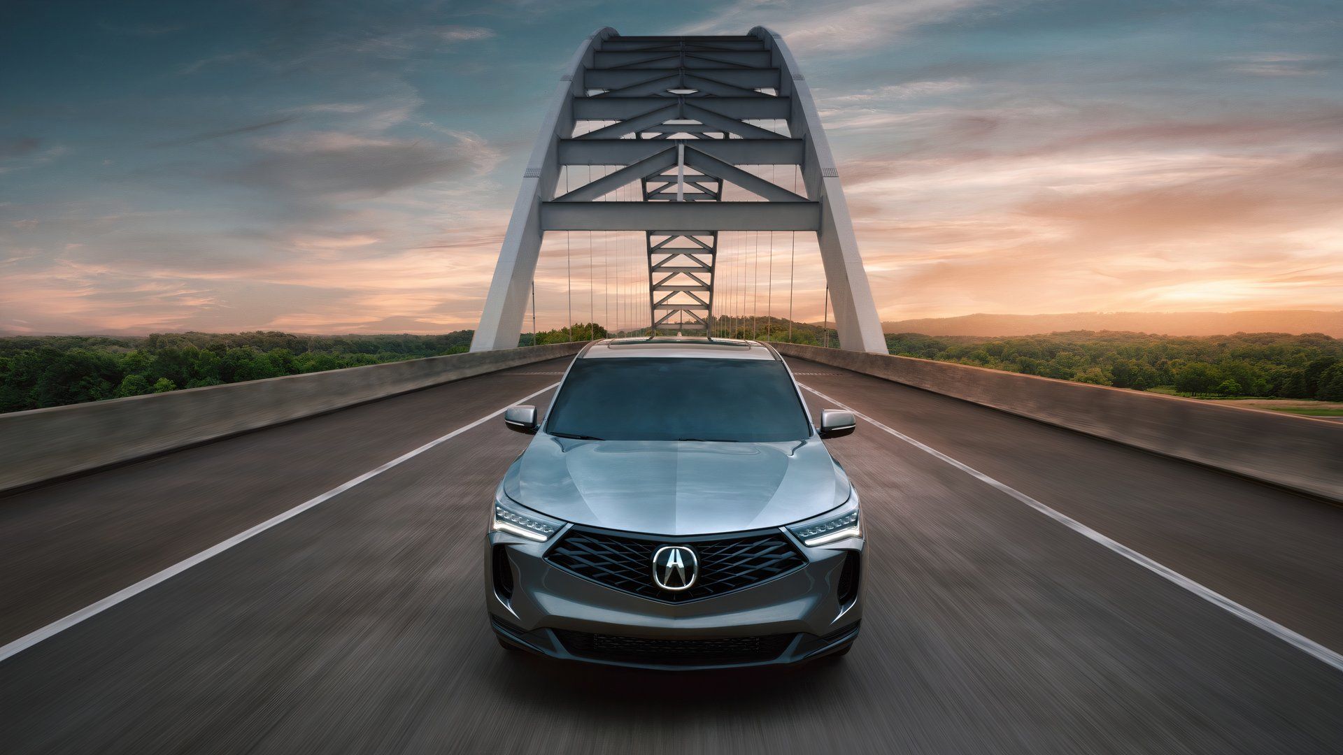 2025 Acura RDX in silver driving over bridge