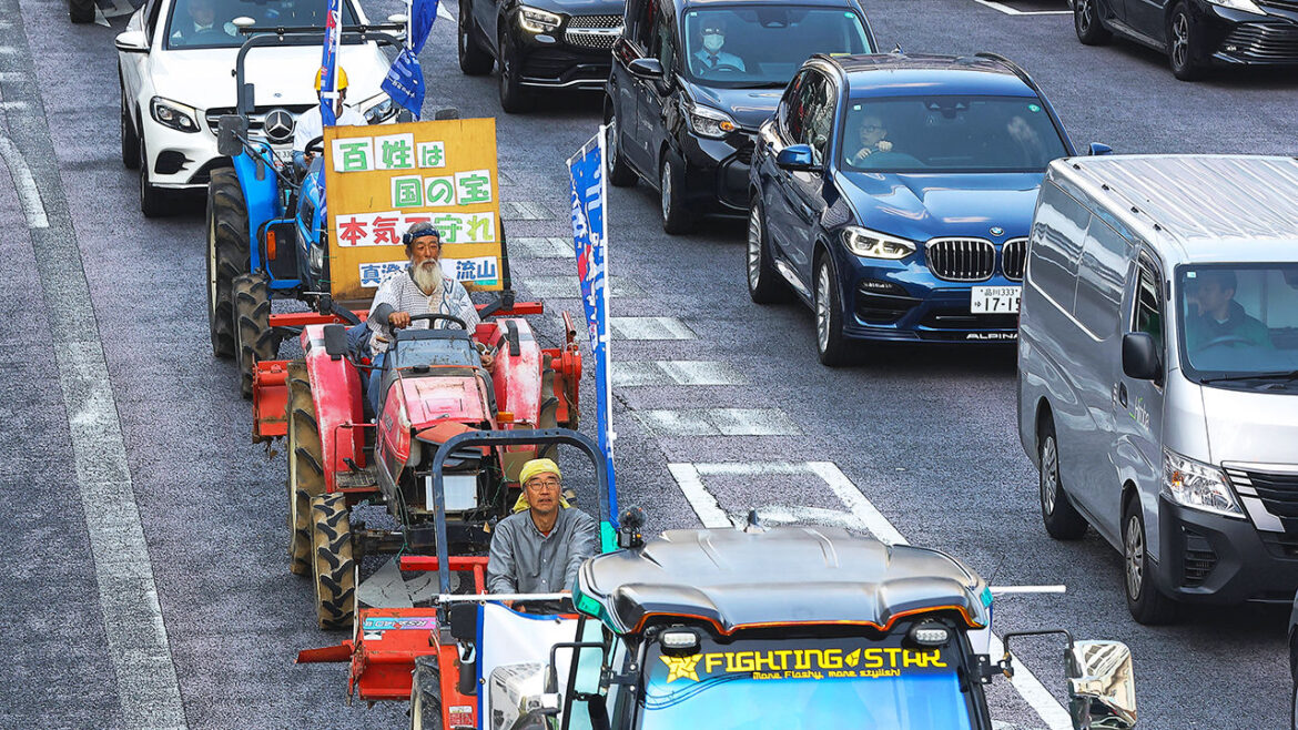 A rice farmer drives a tractor in Tokyo in a protest by rice farmers against the government
