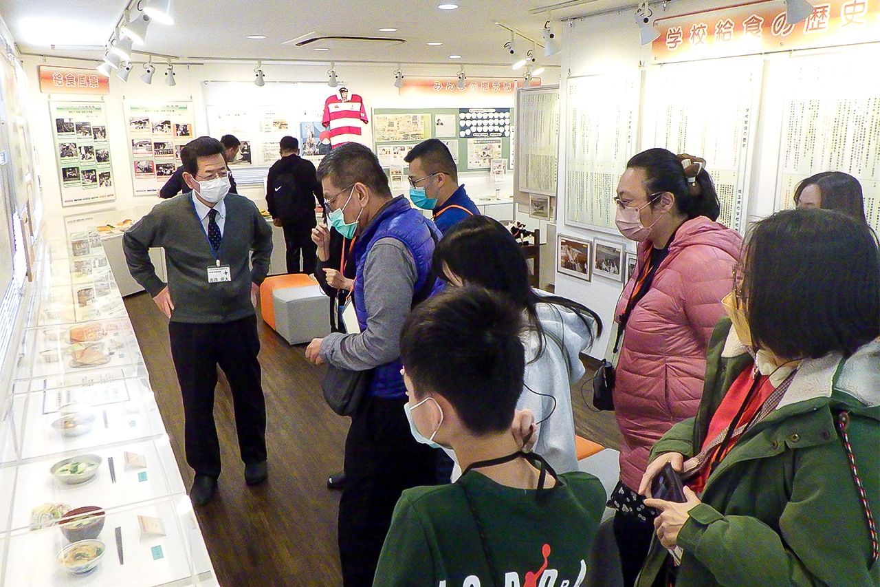Visitors from Taiwan involved in providing school lunches look at exhibits on the history of these meals in Japan. (© School Lunch History Museum)