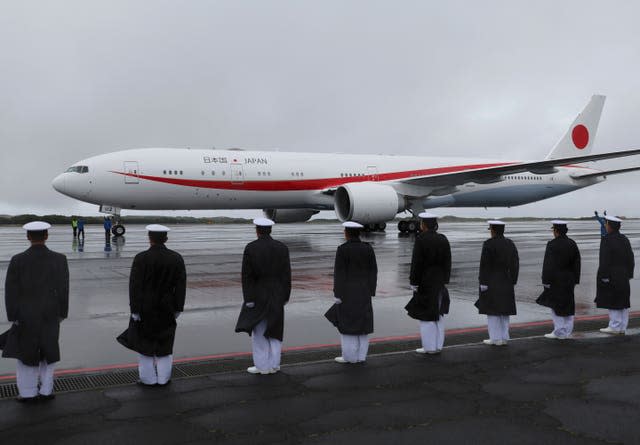 Members of Japan's Self Defence Force stand guard as an airplane carrying Japanese Emperor Naruhito and Empress Masako arrives at the island of Iwo Jima 