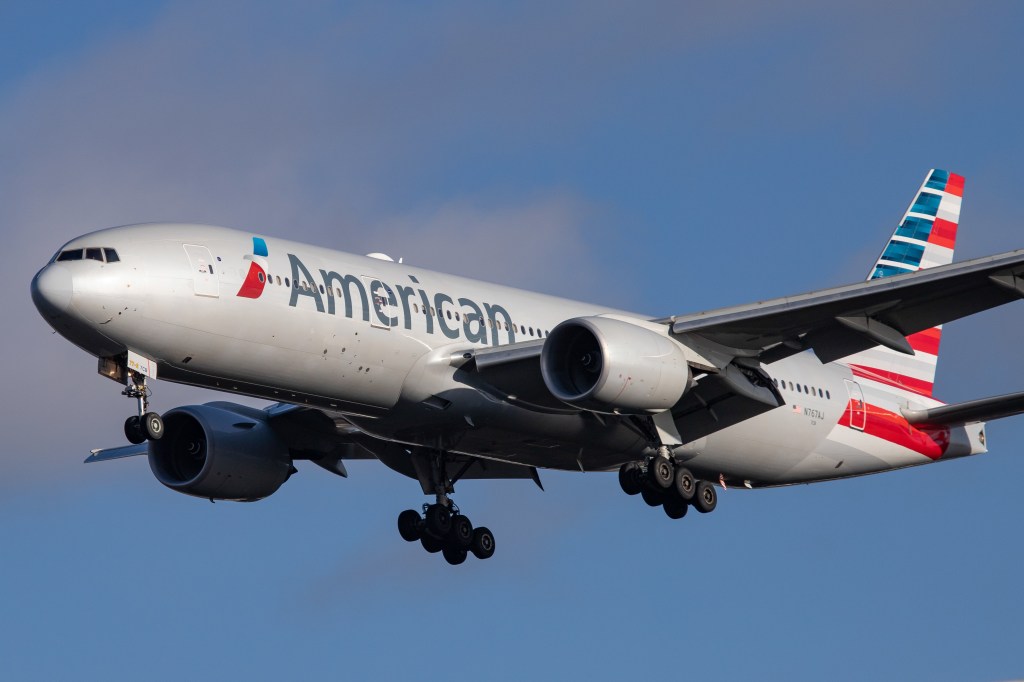 American Airlines Boeing 777-200 plane on final approach to London Heathrow Airport on a sunny day