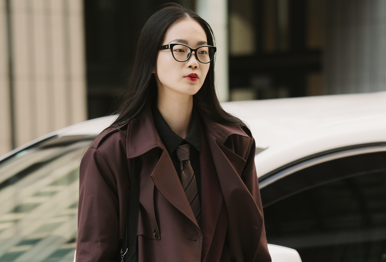 Woman wearing brown coat, brown tie, and red lip during Tokyo Fashion Week.