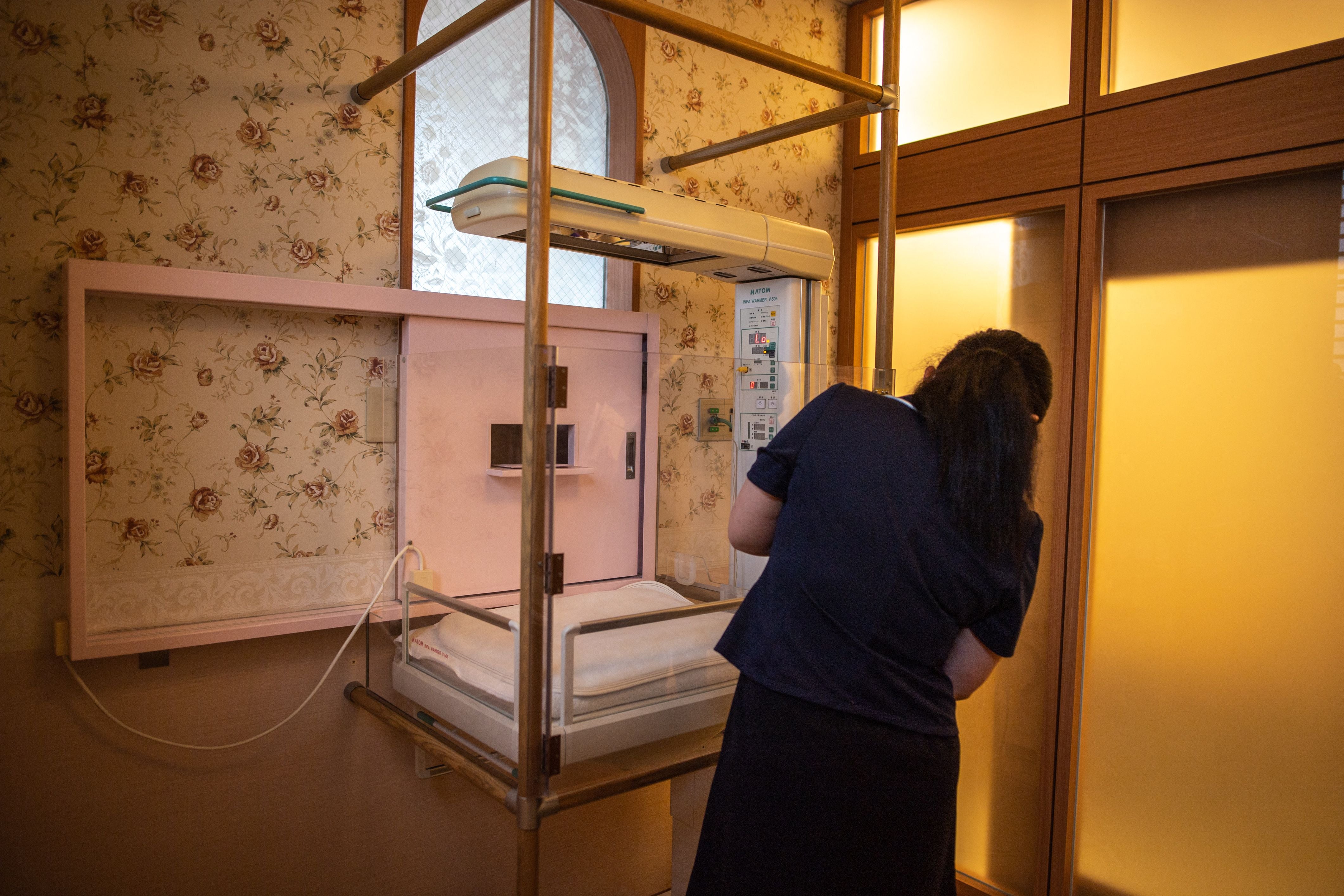 A staff member demonstrates the baby hatch room at Jikei hospital in Kumamoto