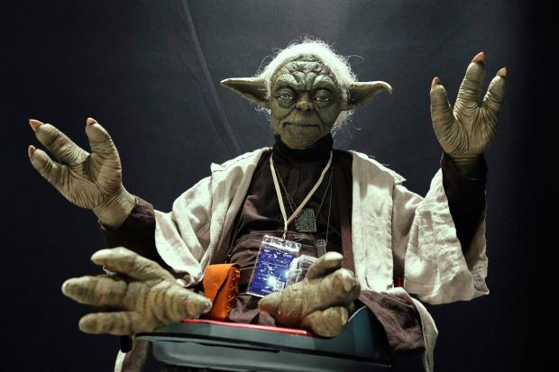 A Star Wars fan dressed as Yoda tries to look...