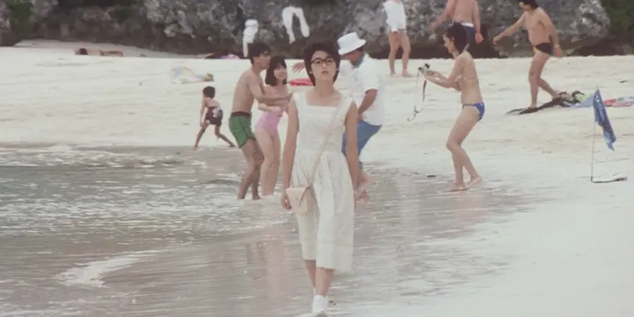 Visit Okinawa. Woman walking along the beach in Okinawa, enjoying the weather