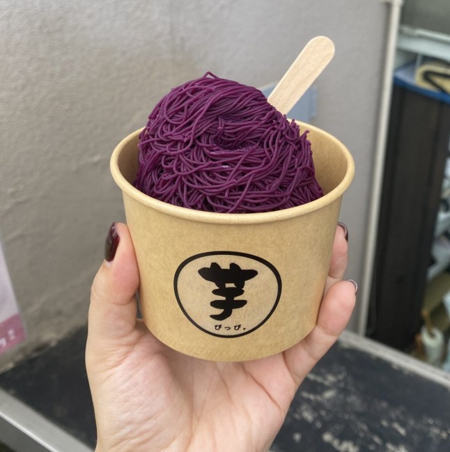 A tub of purple potato ice cream held by a hand