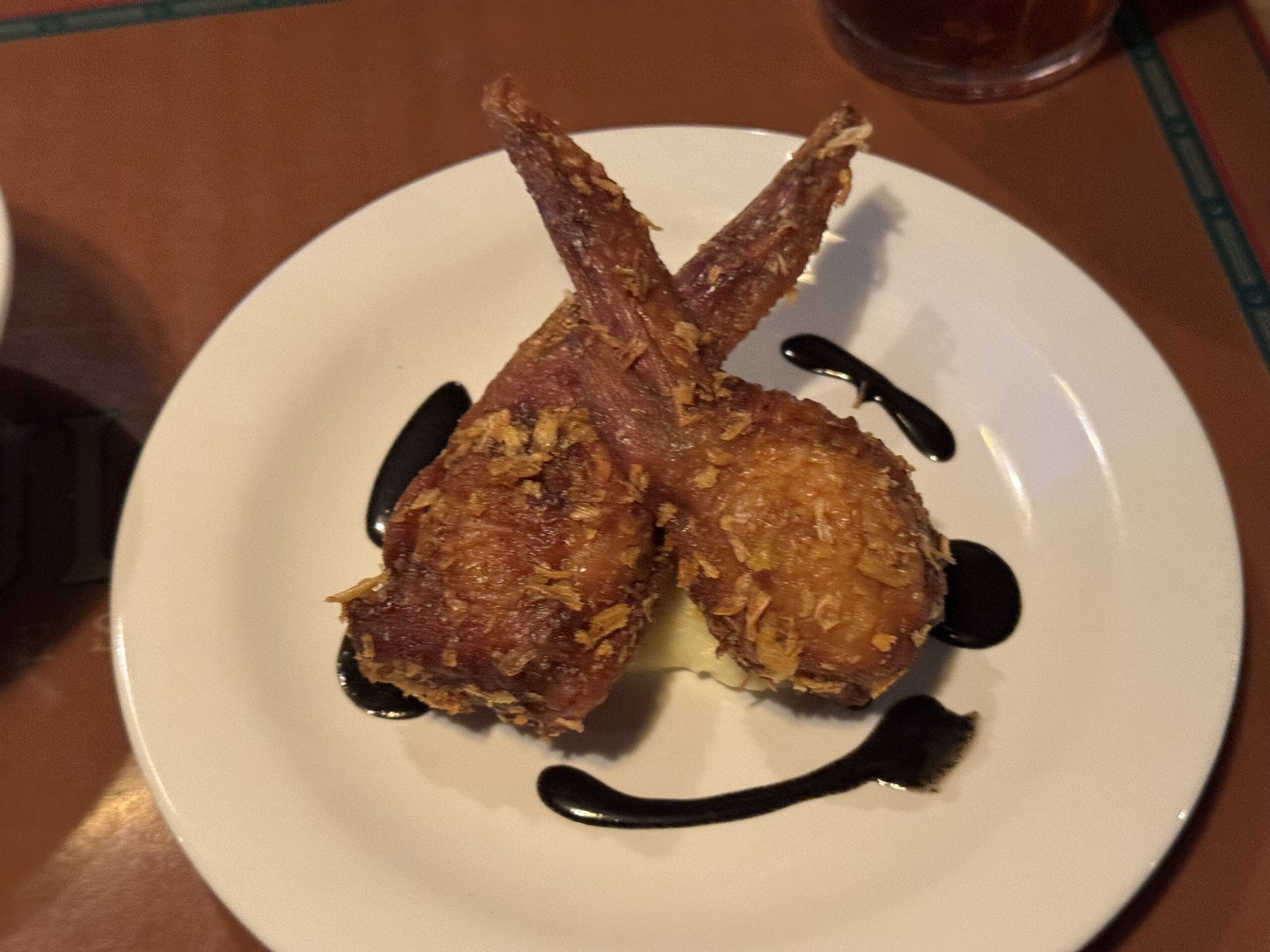 Two crispy fried lamb chops over mashed potatoes, perfect for a 2025 Food and Wine Festival feast.