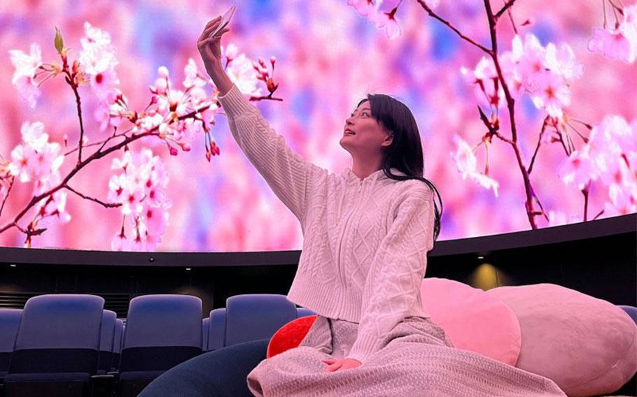 a woman taking photos in the planetarim.