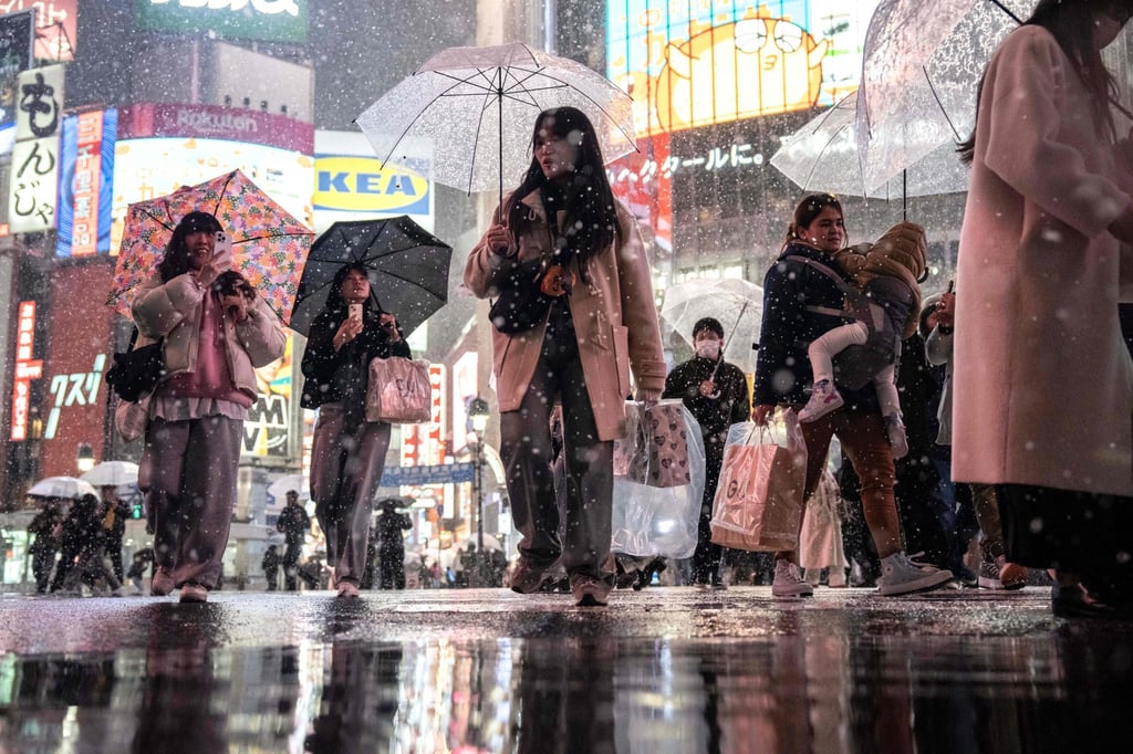 People walk along the Shibuya crossing during snowfall in Tokyo last month. A recent Ipsos survey showed only 15 per cent of Japanese expect their quality of life to improve in coming years. Photo: AFP