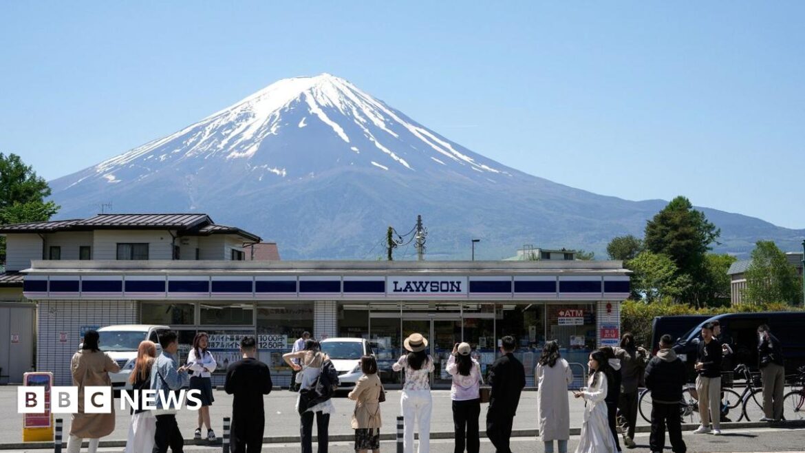 Tourist takes a photo of the supermarket in front of Mount Fuji